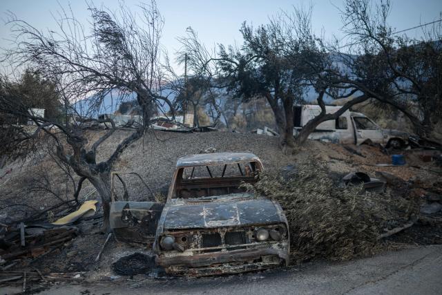 This photograph taken on August 5, 2026, a burnt car after a wildfire in Porto Germeno, some 70 kilometers (45 miles) northwest of Athens. Greek officials and residents of a region west of the capital Athens on August 5, 2026, began to assess the damage suffered by homes, businesses and farmland scorched by a wildfire. (Photo by Angelos TZORTZINIS / AFP)