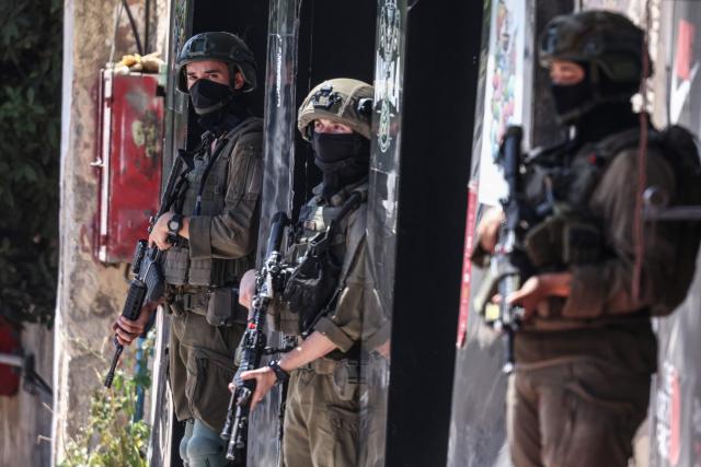 Israeli security forces patrol along a street during a military raid in the Qalandia refugee camp, south of Ramallah in the Israeli-occupied West Bank, on August 5, 2026. Since the start of the Gaza war in October 2023, violence has escalated in the West Bank, which Israel has occupied since 1967. (Photo by Zain JAAFAR / AFP)