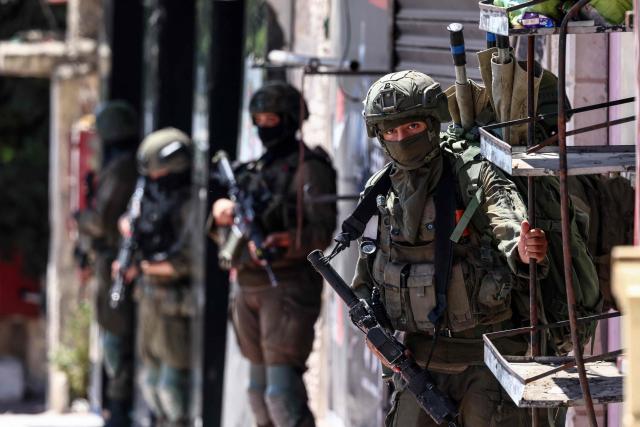 Israeli security forces patrol along a street during a military raid in the Qalandia refugee camp, south of Ramallah in the Israeli-occupied West Bank, on August 5, 2026. Since the start of the Gaza war in October 2023, violence has escalated in the West Bank, which Israel has occupied since 1967. (Photo by Zain JAAFAR / AFP)