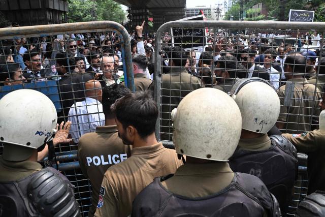 Police personnel restrict Pakistan Tehreek-e-Insaf (PTI) party supporters as they stage a protest demanding the release of their jailed leader and the country's former Prime Minister Imran Khan, in Lahore on August 5, 2026. (Photo by Arif ALI / AFP)