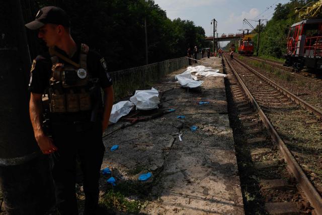 EDITORS NOTE: Graphic content / A policeman stands next to bodies in plastic bags of people killed during Russian ballistic missile and drone strikes, at a railway station in the Kyiv region on August 5, 2026, amid the Russian invasion of Ukraine. Russian missile and drone strikes killed at least 17 people and wounded dozens more in Kyiv and the surrounding region overnight, authorities said on August 5, 2026. (Photo by Mykola TYMCHENKO / AFP)