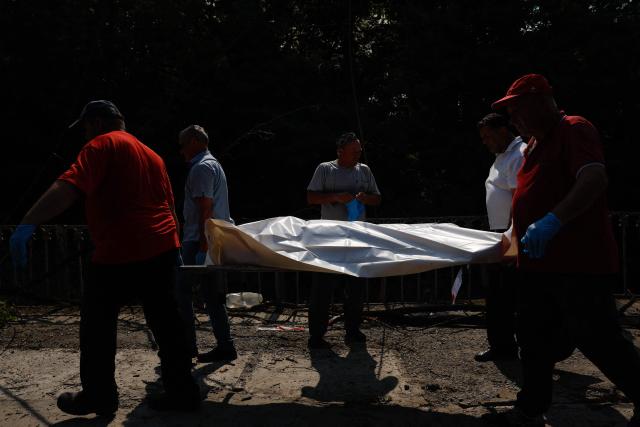 EDITORS NOTE: Graphic content / Men carry a body in a plastic bag of a person killed during Russian ballistic missile and drone strikes at a railway station in the Kyiv region on August 5, 2026, amid the Russian invasion of Ukraine. Russian missile and drone strikes killed at least 17 people and wounded dozens more in Kyiv and the surrounding region overnight, authorities said on August 5, 2026. (Photo by Mykola Tymchenko / AFP)