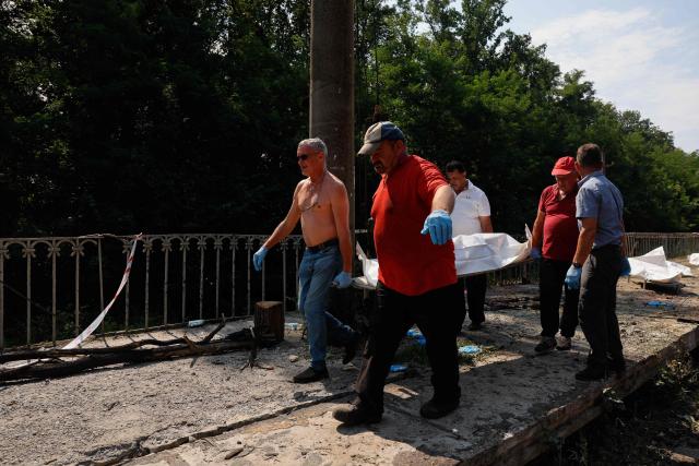 EDITORS NOTE: Graphic content / Men carry a body in a plastic bag of a person killed during Russian ballistic missile and drone strikes at a railway station in the Kyiv region on August 5, 2026, amid the Russian invasion of Ukraine. Russian missile and drone strikes killed at least 17 people and wounded dozens more in Kyiv and the surrounding region overnight, authorities said on August 5, 2026. (Photo by Mykola Tymchenko / AFP)