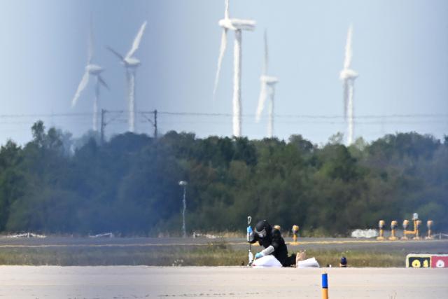 A forensic technician works at the German airport Leipzig-Halle in Schkeuditz, eastern Germany, after an explosives-laden drone was found near a Ukrainian cargo plane. German police deployed a bomb disposal robot at the airport after a drone was found near a Ukrainian-flagged cargo plane overnight, also forcing the diversion of numerous flights. Another aircraft, which had to abort its scheduled landing at Leipzig-Halle airport, then collided mid-air with an unknown object several kilometres away but later landed safely, the government said. The airport in eastern Germany plays a key role in the transport of military goods, including by the German military and NATO allies, and also serves as a base for Ukraine's Antonov Airlines (Photo by Hendrik Schmidt / dpa / AFP) / Germany OUT