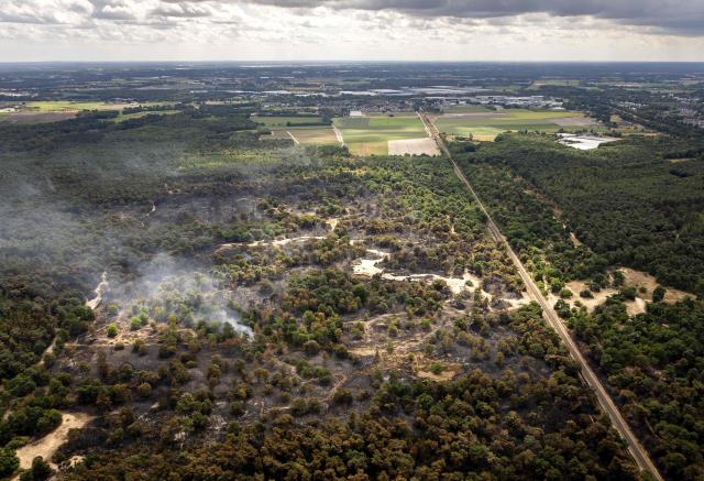 This aerial photograph shows a view of the Boschhuizerbergen nature reserve near Venray in Limburg, where the fire department is battling a large wildfire in Oostrum on August 5, 2026. (Photo by Sem van der Wal / various sources / AFP) / Netherlands OUT