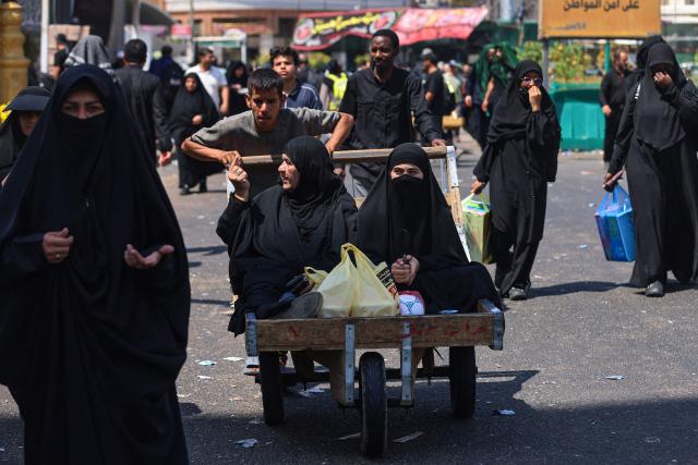 Shia Muslim pilgrims head to a bus station in Iraq's central holy city of Karbala on August 5, 2026, before they head to their hometowns after the conclusion of the Arbaeen pilgrimage, which commemorates 40 days of mourning after the killing of Imam Hussein, the grandson of the Prophet Mohamed, at the 7th-century battle of Karbala. Arbaeen, one the world's largest annual public gathering, marks one of the most significant events in the Shia Muslim calendar, during which pilgrims from various countries visit the holy shrines. (Photo by AHMAD AL-RUBAYE / AFP)
