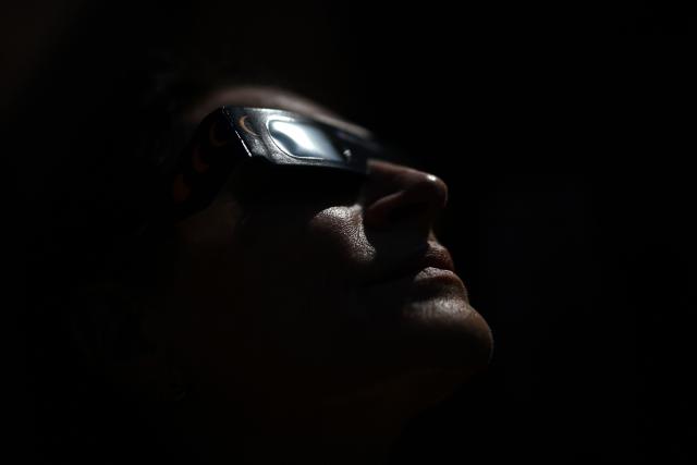 A woman wears to test eclipse-viewing glasses for direct observation of the sun in Beziers, Southern France, on August 5, 2026, ahead of the August 12 solar eclipse. In France, the solar eclipse on August 12 will not be total, but it will still be visible in the late afternoon. Scientists plan to use a total solar eclipse visible in Spain as a rare chance to learn more about the stormy, unpredictable nature of our star. (Photo by Gabriel BOUYS / AFP)