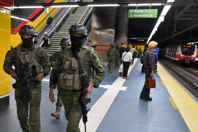 Soldiers patrol a metro station in northern Quito on August 5, 2026. Ecuador deployed 4,000 police officers and military personnel in the capital to reinforce security amid rising violence and recent reports of disappearances. (Photo by Rodrigo BUENDIA / AFP)