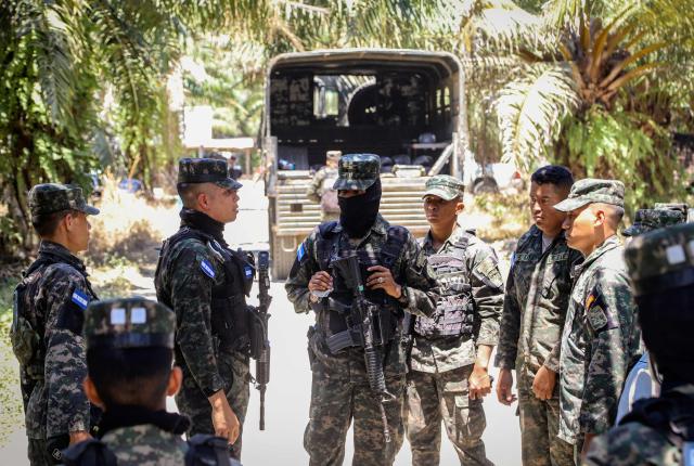 (FILES) Army soldiers prepare to patrol near the site of a massacre in Trujillo, Honduras on May 21, 2026. Six members of the same family were shot dead in northern Honduras, authorities reported on August 5, 2026, attributing the attack to alleged links with drug trafficking. (Photo by AFP)