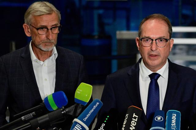 German Interior Minister Alexander Dobrindt (R) and Saxony's Interior Minister Armin Schuster (L) address a press conference at the German airport Leipzig-Halle in Schkeuditz, eastern Germany, after an explosives-laden drone was found near a Ukrainian cargo plane. German police deployed a bomb disposal robot at the airport after a drone was found near a Ukrainian-flagged cargo plane overnight, also forcing the diversion of numerous flights. Another aircraft, which had to abort its scheduled landing at Leipzig-Halle airport, then collided mid-air with an unknown object several kilometres away but later landed safely, the government said. The airport in eastern Germany plays a key role in the transport of military goods, including by the German military and NATO allies, and also serves as a base for Ukraine's Antonov Airlines (Photo by John MACDOUGALL / AFP)