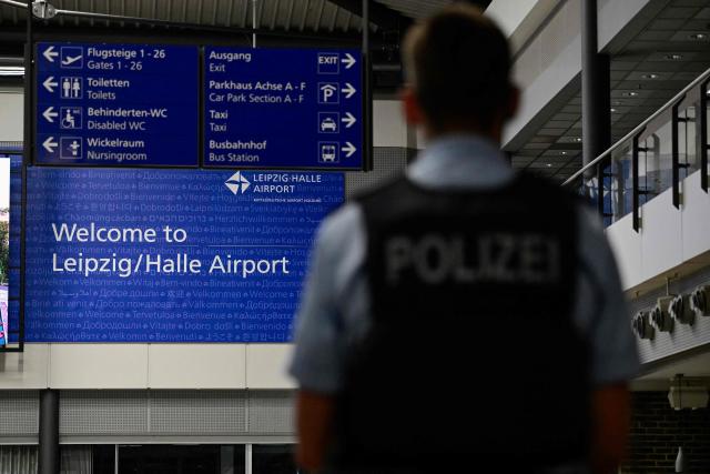 A police officer stands guard in the main hall of the German airport Leipzig-Halle in Schkeuditz, eastern Germany, after an explosives-laden drone was found near a Ukrainian cargo plane. German police deployed a bomb disposal robot at the airport after a drone was found near a Ukrainian-flagged cargo plane overnight, also forcing the diversion of numerous flights. Another aircraft, which had to abort its scheduled landing at Leipzig-Halle airport, then collided mid-air with an unknown object several kilometres away but later landed safely, the government said. The airport in eastern Germany plays a key role in the transport of military goods, including by the German military and NATO allies, and also serves as a base for Ukraine's Antonov Airlines (Photo by John MACDOUGALL / AFP)
