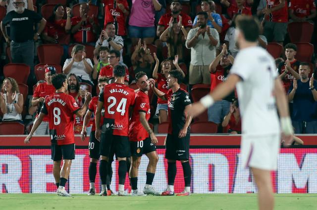 Mallorca's players celebrate their first goal scored by Real Mallorca's Angolan forward #11 Zito Luvumbo during the Ciutat de Palma trophy friendly football match between Mallorca RCD and Paris Saint-Germain FC at Mallorca Son Moix Stadium in Palma de Mallorca on August 8, 2026. (Photo by JAIME REINA / AFP)