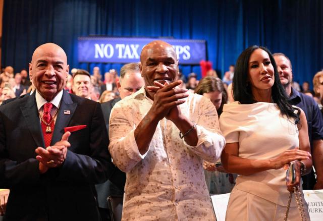 Retired US boxer Mike Tyson (C), his wife Lakiha "Kiki" Spicer (R) and former US boxing referee Joe Cortez applaud during an event with US President Donald Trump to promote his administration's recent tax-relief initiative at Red Rock Casino Resort and Spa in Las Vegas, Nevada, on August 5, 2026. (Photo by Jim WATSON / AFP)