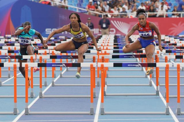 (L to R) Bahamas' Denisha Cartwright, Colombia's Maria Murillo and Cuba's Greisys Roble compete in the women's 100m hurdles final during the XXV Central American and Caribbean Games at the Felix Sanchez Olympic Stadium in Santo Domingo on August 5, 2026. (Photo by Francesco SPOTORNO / AFP)