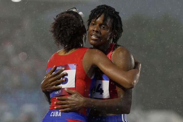 Dominican Republic's Marileidy Paulino (R) greets Cuba's Roxana Gomez after competing in the women's 400m final during the XXV Central American and Caribbean Games at the Felix Sanchez Olympic Stadium in Santo Domingo on August 5, 2026. (Photo by Francesco SPOTORNO / AFP)