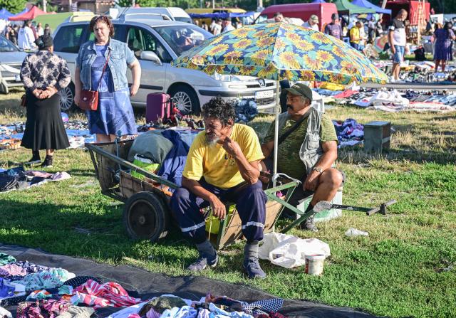 Vendors sell second hand garments spread on the ground at the open-air market in the city of Calarasi, Romania, on July 26, 2026. As the eastern European country has struggled for months with the highest inflation in the European Union, almost 11 percent in May, several buyers complained of rising prices which forced them to make difficult decisions about what to cut. (Photo by Daniel MIHAILESCU / AFP)
