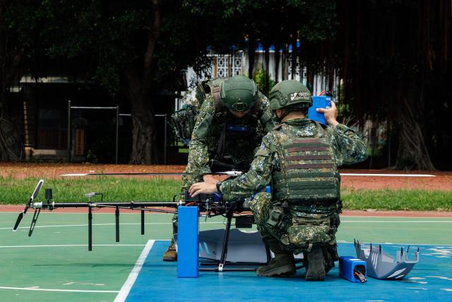 Taiwanese military personnel replace the battery of a Tactical-2 unmanned aerial vehicle (UAV) during a combat-readiness training in Chang-Hua County on August 6, 2026. The annual "Han Kuang" exercise, which runs from August 5-14, stages combat scenarios for troops and reservists to practise responding to an attack on the island, defence officials say. (Photo by CHENG Yu-chen / AFP)