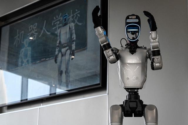 The photo taken on August 4, 2026 shows a robot named Wuji, which manufactured by Unitree, giving a guided tour to visitors at the Hangzhou Robot school in Hangzhou, in eastern China's Zhejiang province. (Photo by Jade GAO / AFP)