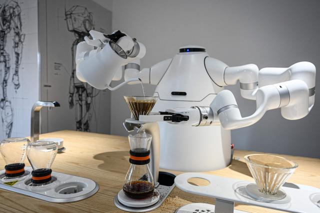 The photo taken on August 4, 2026 shows a robot manufactured by Zhejiang University Robot Research Institute making making coffee at the Hangzhou Robot school in Hangzhou, in eastern China's Zhejiang province. (Photo by Jade GAO / AFP)