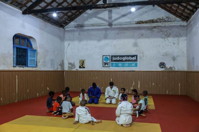 Judo instructor from Portugal Andre Mendes Rosa (C-R), 38, and Sao Tome and Principe's Nelson Pina (C-L) practitioner and instructor supervise young judokas in one of Judo Global dojos in Santo Antonio, in Principe Island in Sao Tome and Principe, on August 5, 2026. Andre Mendes Rosa, president and founder of Judo Global, set up the association to enable young people to discover the sport and develop through sport and education. The organisation now has six centres, three on the island of Sao Tome and three on the island of Principe. It is recognised by the International Judo Federation, and athletes from Judo Global centres take part in national, regional and even international competitions with a judoka from Sao Tome and Principe, for the first time, took part in the Olympic Games in Paris in 2024. (Photo by Daniel BELOUMOU OLOMO / AFP)
