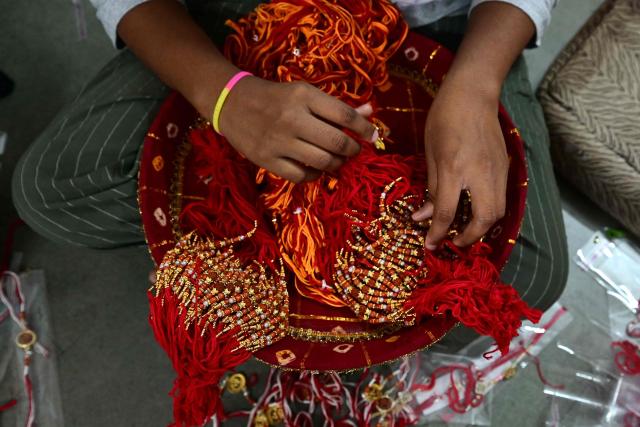 A visually impaired woman prepares 'rakhis' or ceremonial wristbands, at the Andh Kanya Prakash Gruh School for the Blind in Ahmedabad on August 6, 2026 ahead of the upcoming Hindu festival of Raksha Bandhan. (Photo by Shammi MEHRA / AFP)