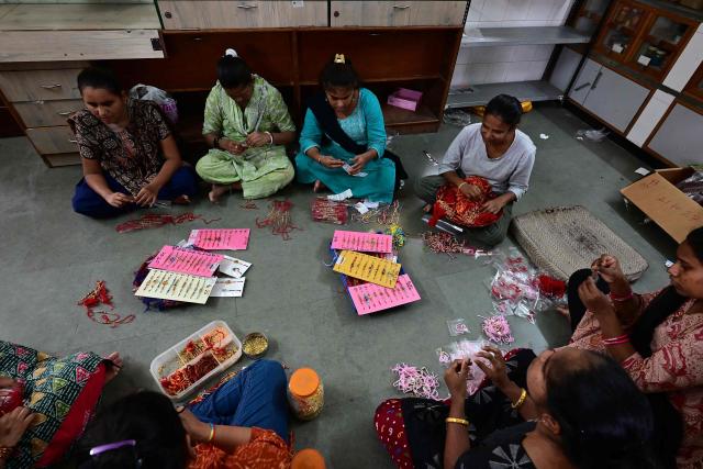 Visually impaired women prepare 'rakhis' or ceremonial wristbands, at the Andh Kanya Prakash Gruh School for the Blind in Ahmedabad on August 6, 2026 ahead of the upcoming Hindu festival of Raksha Bandhan. (Photo by Shammi MEHRA / AFP)