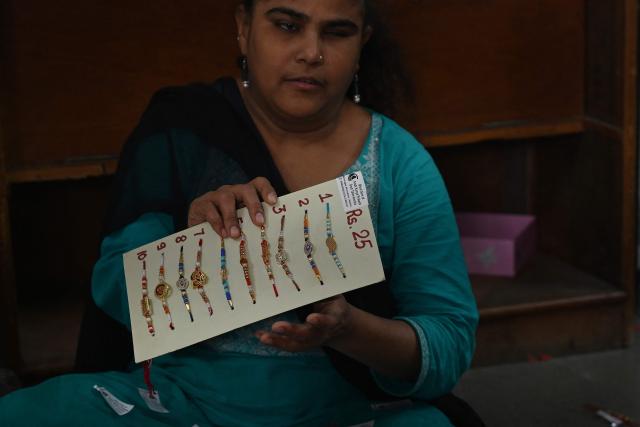 A visually impaired woman prepares 'rakhis' or ceremonial wristbands, at the Andh Kanya Prakash Gruh School for the Blind in Ahmedabad on August 6, 2026 ahead of the upcoming Hindu festival of Raksha Bandhan. (Photo by Shammi MEHRA / AFP)
