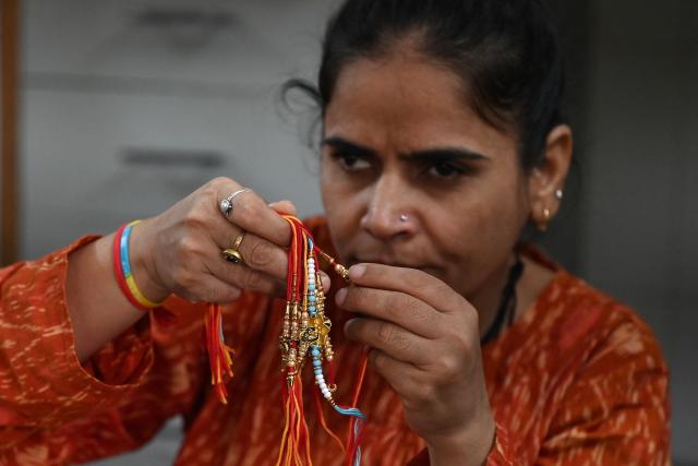 A visually impaired woman prepares 'rakhis' or ceremonial wristbands, at the Andh Kanya Prakash Gruh School for the Blind in Ahmedabad on August 6, 2026 ahead of the upcoming Hindu festival of Raksha Bandhan. (Photo by Shammi MEHRA / AFP)