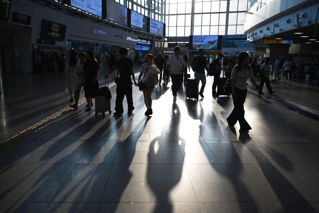 People walk through Seoul Railway Station in Seoul on August 6, 2026. (Photo by GREG BAKER / AFP)