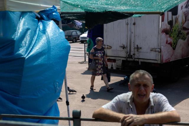 A woman walks in a damaged street market following a Russian strikes in Kyiv on August 6, 2026, amid the Russian invasion of Ukraine. Russian missile and drone strikes killed at least 17 people and wounded dozens more in Kyiv and the surrounding region overnight, authorities said on August 5, 2026. (Photo by Tetiana DZHAFAROVA / AFP)