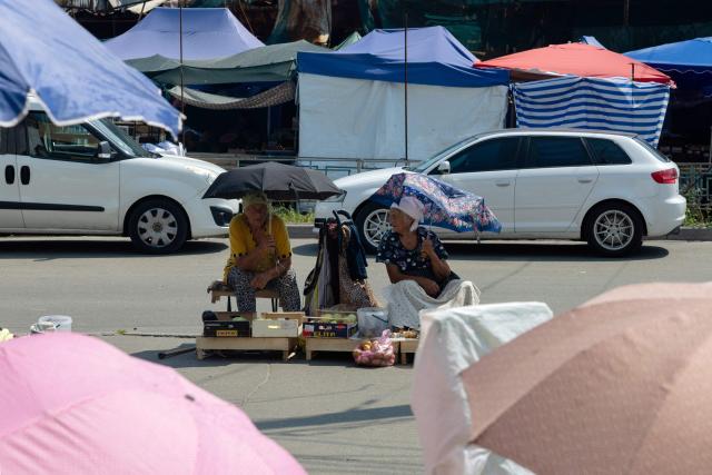 Vendors sell goods at a damaged street market following strikes in Kyiv on August 6, 2026, amid the Russian invasion of Ukraine. Russian missile and drone strikes killed at least 17 people and wounded dozens more in Kyiv and the surrounding region overnight, authorities said on August 5, 2026. (Photo by Tetiana DZHAFAROVA / AFP)
