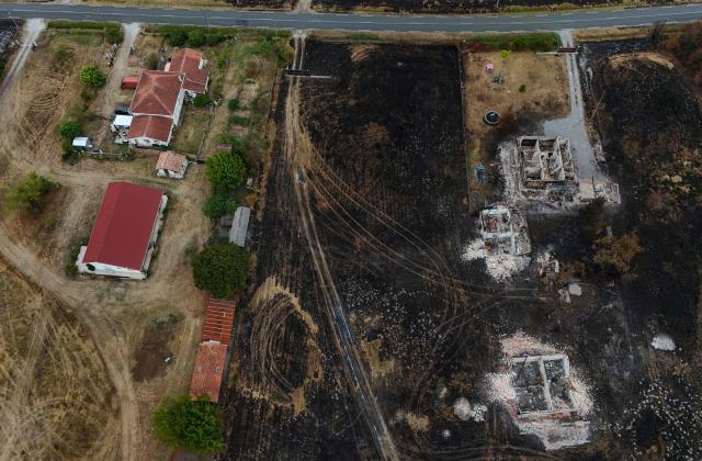 This aerial photograph shows burnt (R) and intact properties in an area hit by the wildfire that swept through the Gironde region in Le Porge, south-western France on August 6, 2026. Around 240 homes were destroyed by the flames, three-quarters of them in the municipality of Le Porge (population 3,500), according to a provisional assessment. No fatalities or civilian injuries have been reported. (Photo by Christophe ARCHAMBAULT / AFP)