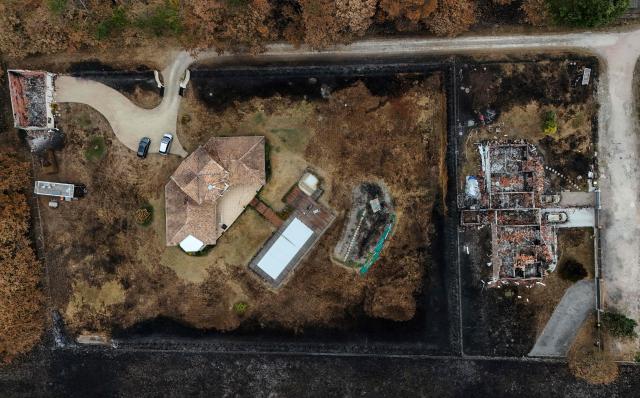 This aerial photograph shows a burnt (R) and an intact property in an area hit by the wildfire that swept through the Gironde region in Le Porge, south-western France on August 6, 2026. Around 240 homes were destroyed by the flames, three-quarters of them in the municipality of Le Porge (population 3,500), according to a provisional assessment. No fatalities or civilian injuries have been reported. (Photo by Christophe ARCHAMBAULT / AFP)