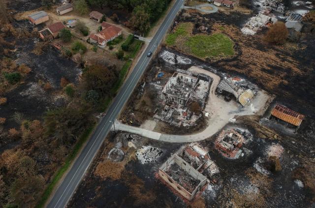This aerial photograph shows burnt properties (R) in an area hit by the wildfire that swept through the Gironde region in Le Porge, south-western France on August 6, 2026. Around 240 homes were destroyed by the flames, three-quarters of them in the municipality of Le Porge (population 3,500), according to a provisional assessment. No fatalities or civilian injuries have been reported. (Photo by Christophe ARCHAMBAULT / AFP)