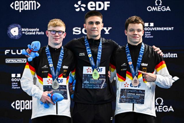 (From L) Silver medallist Germany's diver Jaden Shiloh Eikermann Gregorchuk, gold medallist Neutral Athletes diver Ruslan Ternovoi and bronze medallist Germany's diver Ole Johannes Rosler celebrate on the podium after the men's 10m platform diving final event during the LEN European Aquatics Championships, at the Olympic Aquatics Centre in Saint-Denis, northeastern suburbs of Paris on August 6, 2026. (Photo by JULIEN DE ROSA / AFP)