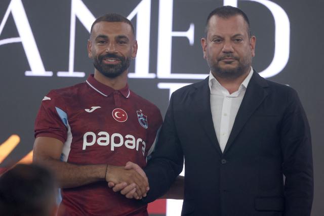 Trabzonspor's Egyptian forward Mohamed Salah (L) shakes hands with President of Trabzonspor Ertugrul Dogan during his signing cerenomy at Papara Park Stadium in Trabzon on August 6, 2026. Former Liverpool star Mohamed Salah on August 6, 2026 signed a two-year contract with Turkish club Trabzonspor after leaving the Premier League giants at the end of his contract. (Photo by Nurgul GUNAYDIN / AFP)