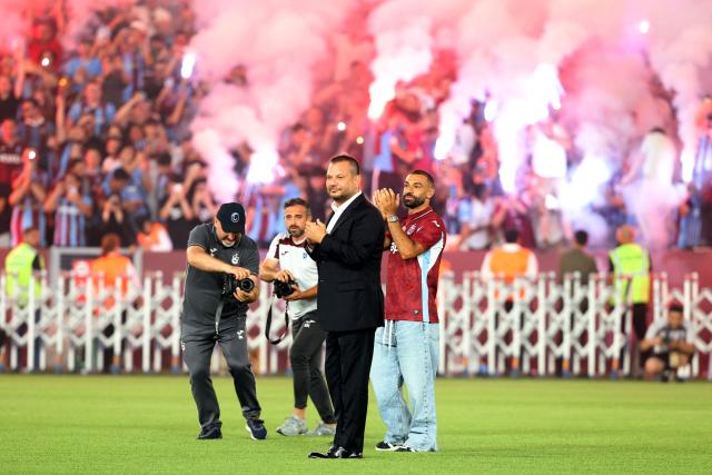 Trabzonspor's Egyptian forward Mohamed Salah (R) and President of Trabzonspor Ertugrul Dogan (C) walk on the pitch during his signing cerenomy at Papara Park Stadium in Trabzon on August 6, 2026. Former Liverpool star Mohamed Salah on August 6, 2026 signed a two-year contract with Turkish club Trabzonspor after leaving the Premier League giants at the end of his contract. (Photo by Nurgul GUNAYDIN / AFP)