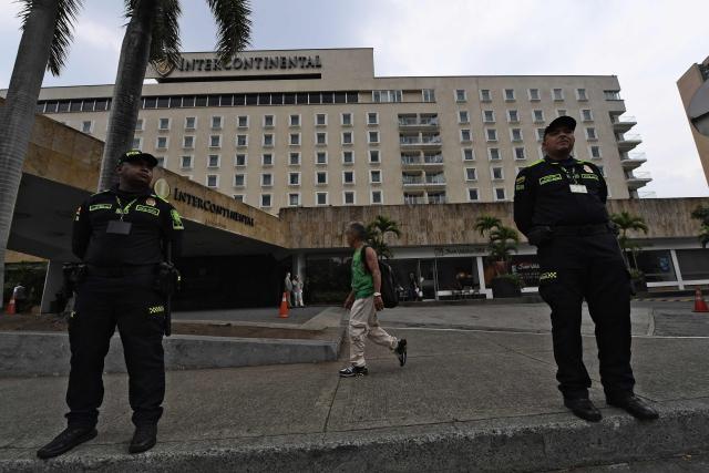 Police officers stand guard outside the InterContinental Hotel in Cali, Colombia, on August 6, 2026, on the eve of the inauguration of Colombian president-elect Abelardo de la Espriella. (Photo by Jaime SALDARRIAGA / AFP)