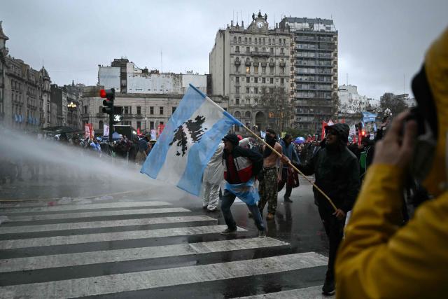 Riot police fire a water cannon to disperse demonstrators protesting outside the National Congress in Buenos Aires on August 6, 2026, as senators debate a bill on the inviolability of private property. (Photo by Luis ROBAYO / AFP)