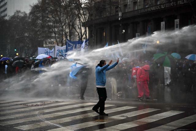 Riot police fire a water cannon to disperse demonstrators protesting outside the National Congress in Buenos Aires on August 6, 2026, as senators debate a bill on the inviolability of private property. (Photo by Luis ROBAYO / AFP)