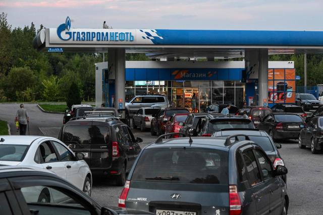 People queue to refuel their cars at a Gazpromneft petrol station on the outskirts of Pereslavl-Zalesskiy on August 6, 2026. Russia -- one of the world's largest oil producers -- introduced a swath of restrictions on petrol sales across the country in June, as Ukrainian strikes on its refineries, depots and logistics crimp domestic supply. Several regions have introduced rationing, while some gas stations and chains have sold out or closed due to a lack of supplies. (Photo by Igor IVANKO / AFP)
