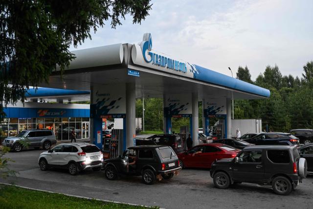 People queue to refuel their cars at a Gazpromneft petrol station on the outskirts of Pereslavl-Zalesskiy on August 6, 2026. Russia -- one of the world's largest oil producers -- introduced a swath of restrictions on petrol sales across the country in June, as Ukrainian strikes on its refineries, depots and logistics crimp domestic supply. Several regions have introduced rationing, while some gas stations and chains have sold out or closed due to a lack of supplies. (Photo by Igor IVANKO / AFP)