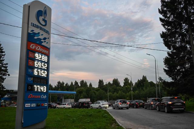 People queue to refuel their cars at a Gazpromneft petrol station on the outskirts of Pereslavl-Zalesskiy on August 6, 2026. Russia -- one of the world's largest oil producers -- introduced a swath of restrictions on petrol sales across the country in June, as Ukrainian strikes on its refineries, depots and logistics crimp domestic supply. Several regions have introduced rationing, while some gas stations and chains have sold out or closed due to a lack of supplies. (Photo by Igor IVANKO / AFP)