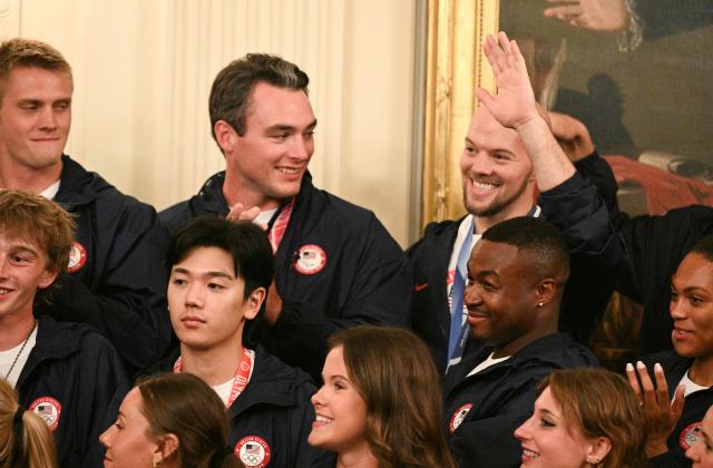 Gold medalist figure skater Daniel O'Shea waves after being mentioned by US President Donald Trump during an event welcoming Team USA Olympic and Paralympic winter athletes in the East Room of the White House in Washington, DC, on August 6, 2026. (Photo by Jim WATSON / AFP)