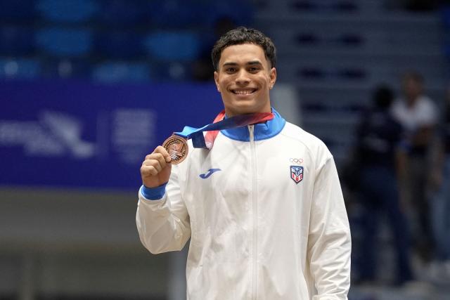 Puerto Rico's Jensuel Soto poses on the podium after winning the bronze medal in the men's vault final during the XXV Central American and Caribbean Games in Santo Domingo on August 6, 2026. (Photo by Francesco SPOTORNO / AFP)