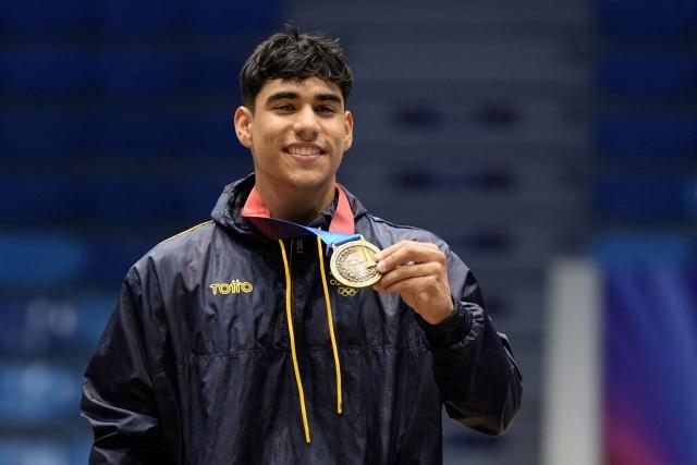 Colombia's Angel Barajas poses on the podium after winning the gold medal in the men's horizontal bar final during the XXV Central American and Caribbean Games in Santo Domingo on August 6, 2026. (Photo by Francesco SPOTORNO / AFP)