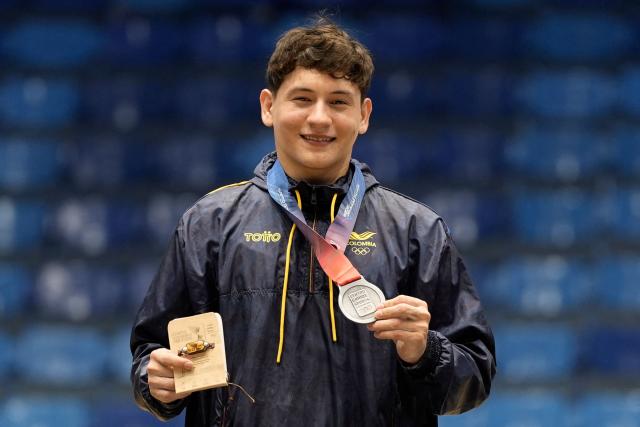 Colombia's Yan Dairo Zabala poses on the podium after winning the silver medal in the men's horizontal bar final during the XXV Central American and Caribbean Games in Santo Domingo on August 6, 2026. (Photo by Francesco SPOTORNO / AFP)