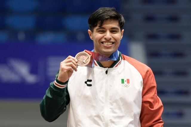 Mexico's Isaac Nunez poses on the podium after winning the bronze medal in the men's horizontal bar final during the XXV Central American and Caribbean Games in Santo Domingo on August 6, 2026. (Photo by Francesco SPOTORNO / AFP)