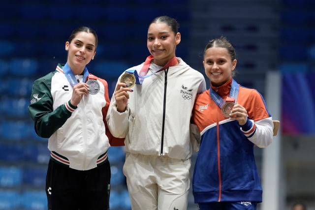Panama's Alyiah Lide (C), Mexico's Paulina Guerra (L) and Costa Rica's Samantha Marin pose on the podium after winning the gold, silver and bronze medals, respectively, in the women's floor exercise final during the XXV Central American and Caribbean Games in Santo Domingo on August 6, 2026. (Photo by Francesco SPOTORNO / AFP)