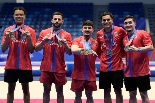(L to R) Puerto Rican gymnasts Nelson Guilbe, Jose Antonio Lopez, Francisco Velez, Jensuel Soto and Pablo Perez pose with their medals after the artistic gymnastics competition at the XXV Central American and Caribbean Games in Santo Domingo on August 6, 2026. (Photo by Francesco SPOTORNO / AFP)